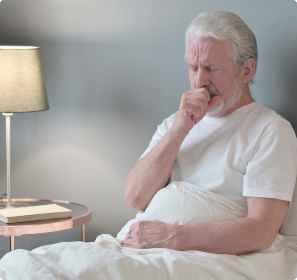 a man coughing on the bed
