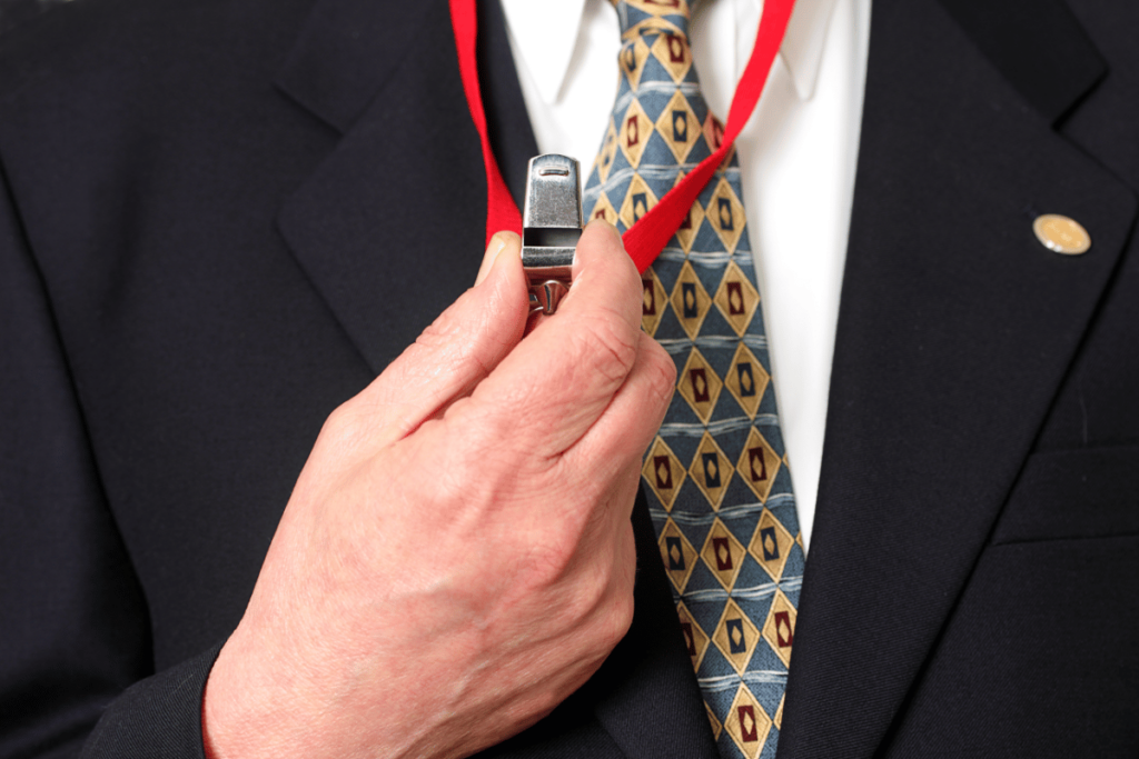 closeup of man in suit holding a whistle