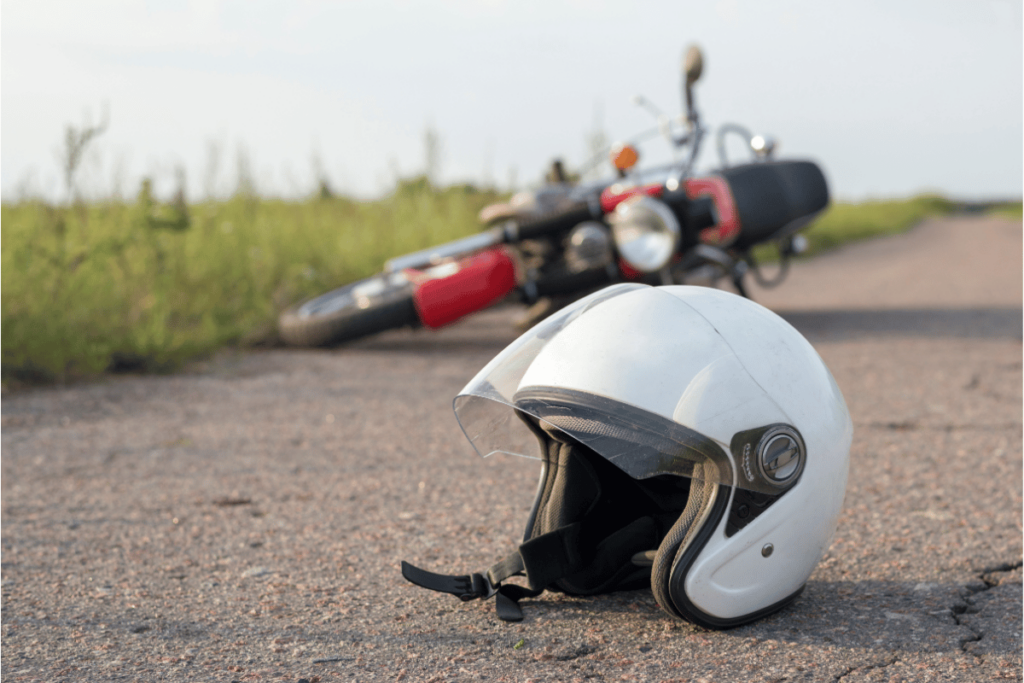closeup of helmet on road infront of overturned motorcycle