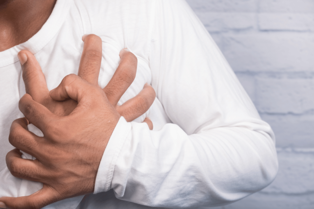 closeup of man holding hand in pain close to his chest