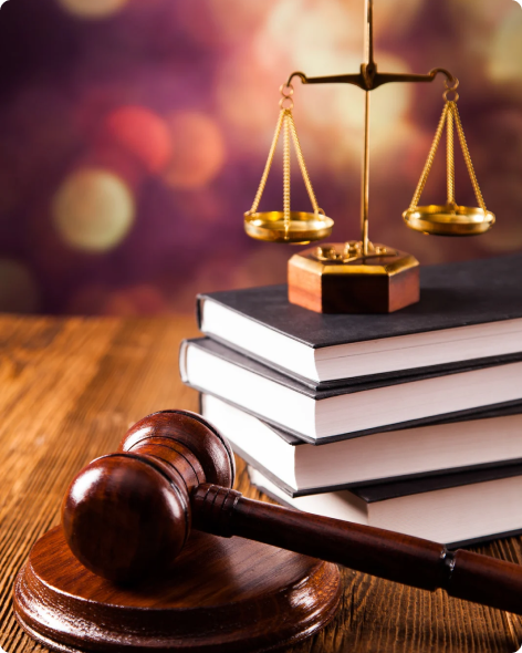 a gavel and a justice scale placed on a stack of books