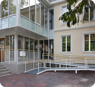 A traditional house with a modern glass extension, two stories, with glass walls.