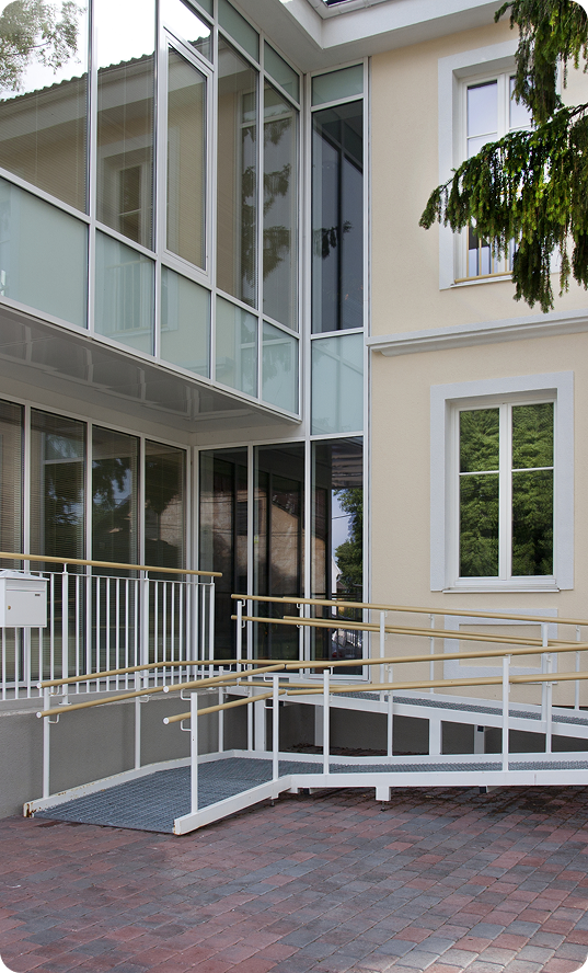 A traditional house with a modern glass extension, two storeys, with glass walls.