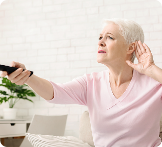 Senior woman cupping her hand behind ear to hear better