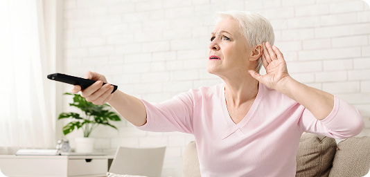 Senior woman cupping her hand behind ear to hear better