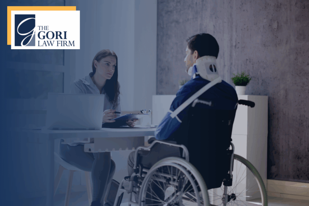 A person in a wheelchair with a neck brace talking to an intake person