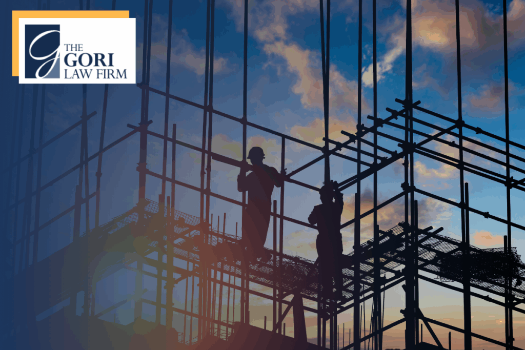 Two construction workers on the second floor of a metal framed building. The Gori Law Firm