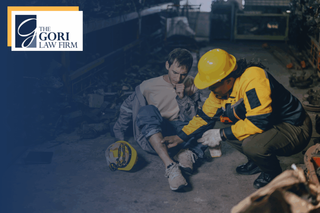 An injured worker laying on the ground while someone looks over their injury. The Gori Law Firm