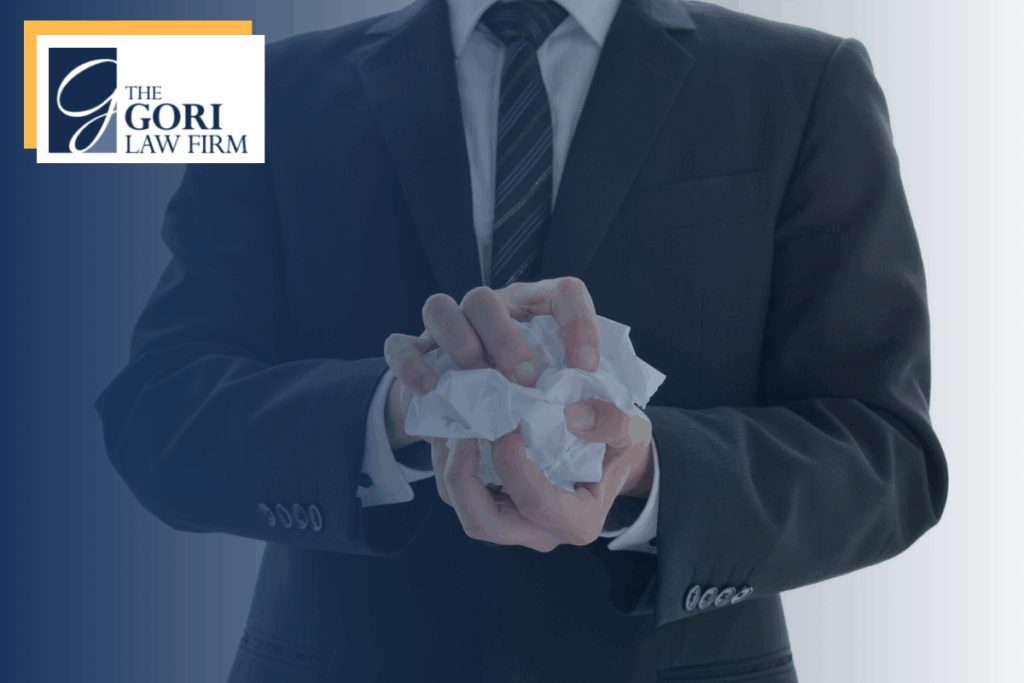 A man holding a crumbled up piece of paper. The Gori Law Firm Retaliatory Termination Lawyers